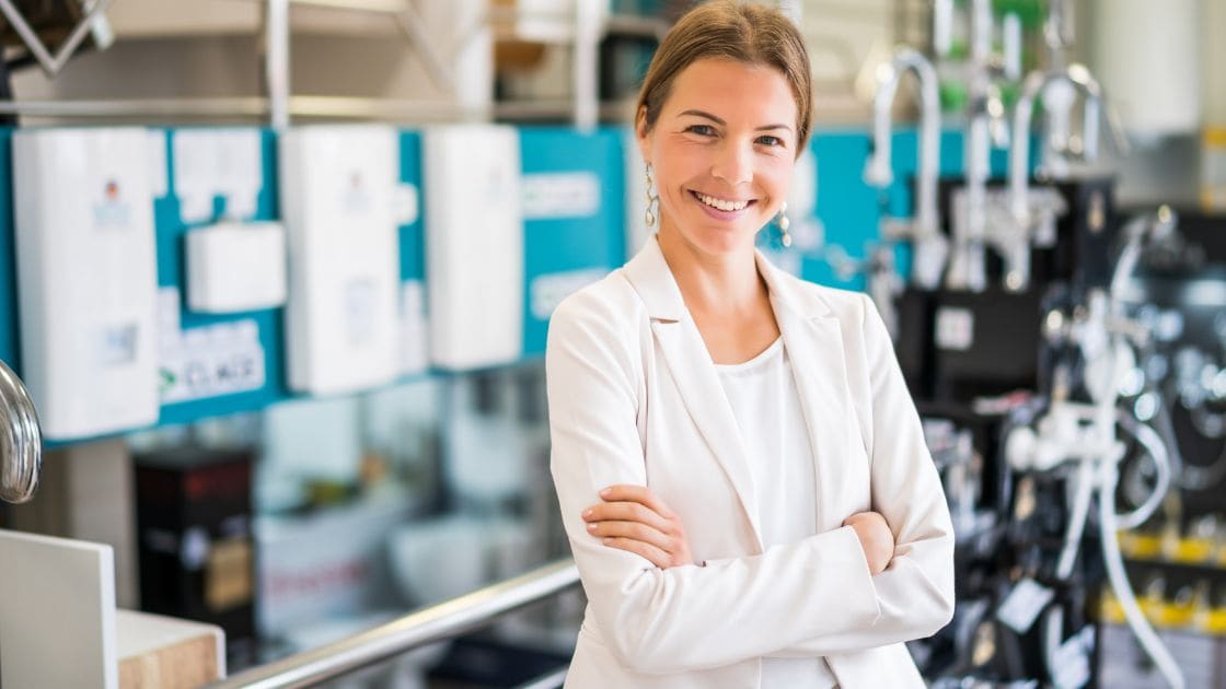 Fachkraft im weißen Blazer steht in industrieller Umgebung – Symbol für Führung, Technik und moderne Arbeitswelt.