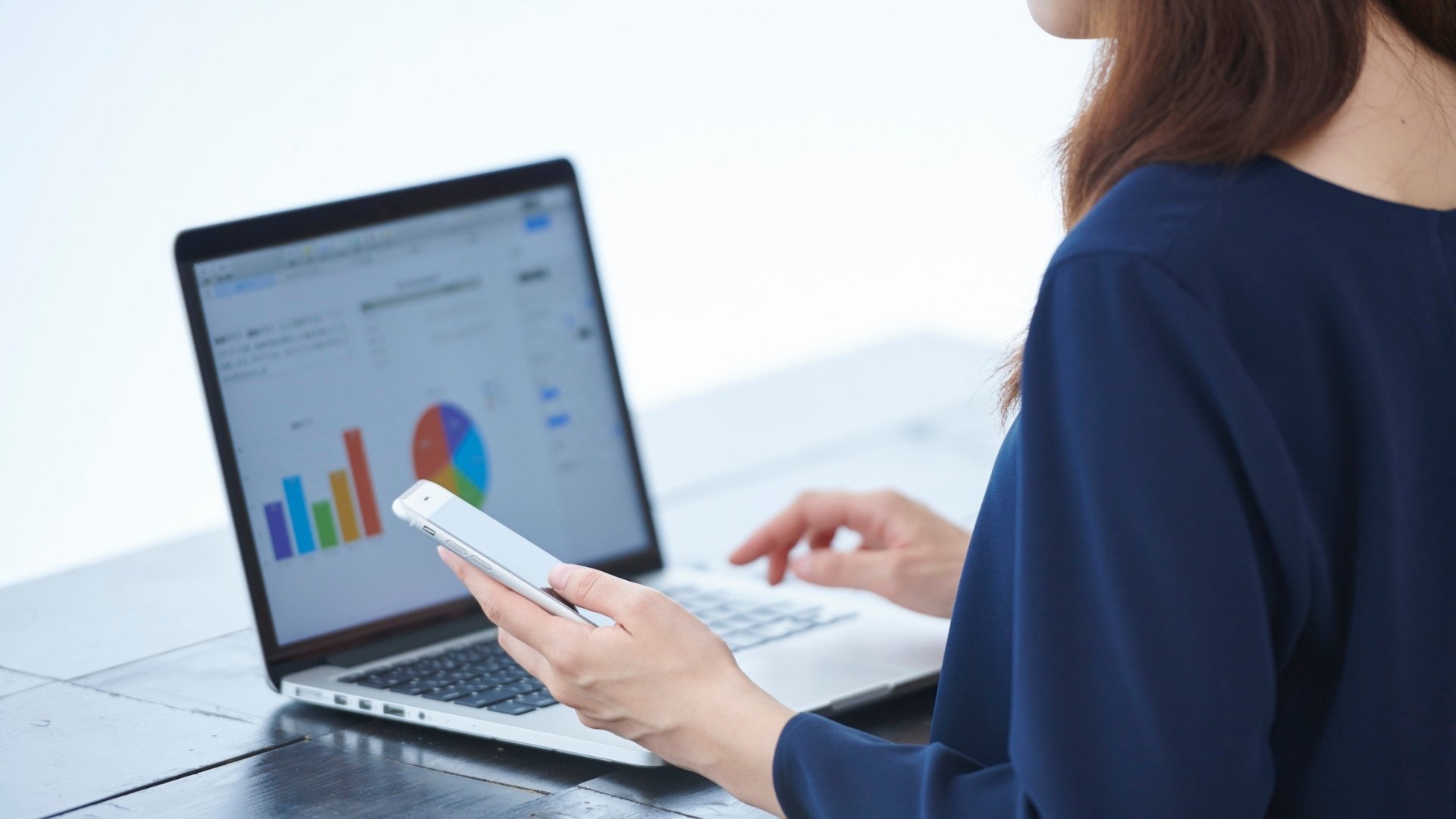 Profissional analisando gráficos de desempenho em laptop, representando otimização contínua de páginas